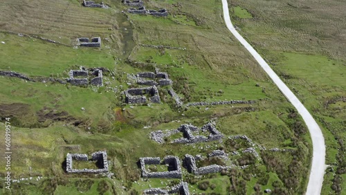 Settlement rock wall ruins along path in desereted village at slievemore, achill island ireland photo