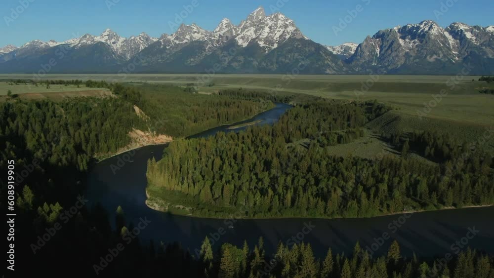 Aerial Cinematic Drone Jackson Hole Grand iconic Tetons Wyoming Snake River Spring greenery with snow capped mountain peaks vista point outlook turn out blue sky morning slowly pan up forward movement