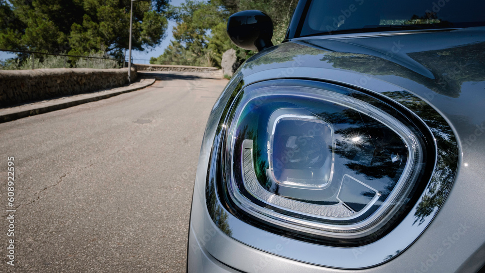 Headlight of a silver classic car.