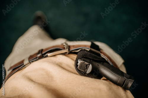 a concealed weapon in a holster behind his belt, photo