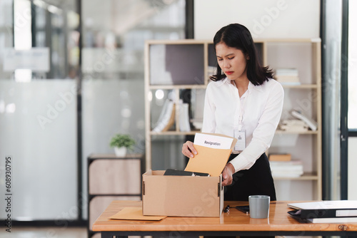 Resignation concept. Fired employee holding box of belongings in an office