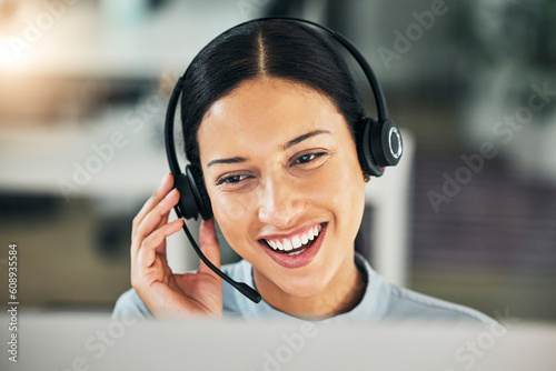 Happy woman, call center and face with a headset at computer for customer service or sales. Smile of a consultant person talking at a pc with a microphone for telemarketing, crm or help desk support