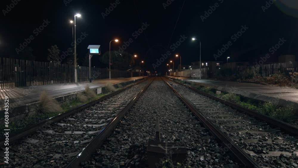 Empty train tracks in a rural countryside town at night Empty train tracks in a rural countryside town at night