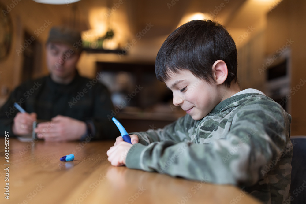 Military man in olive uniform playing sea battle and have fun with his little son at home