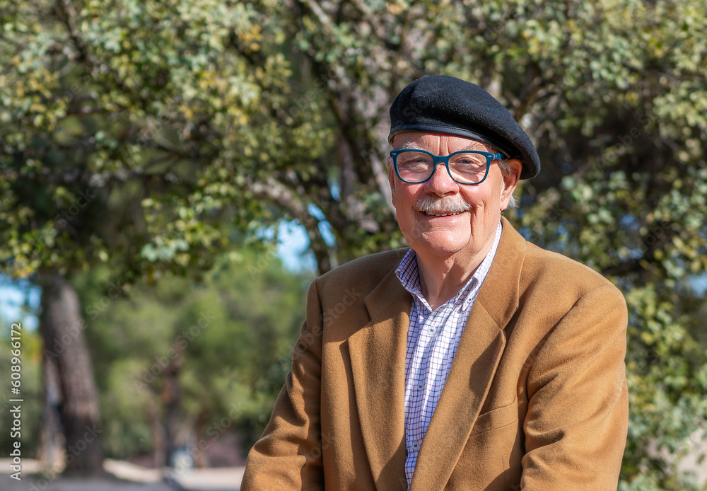 mature man with white mustache in the park on a sunny day smiling and looking at camera mature man with white mustache in the park on a sunny day smiling and looking at camera