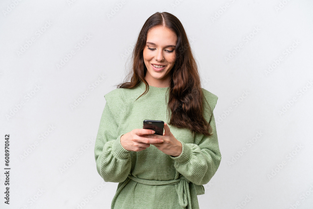 Young caucasian woman isolated on white background sending a message with the mobile