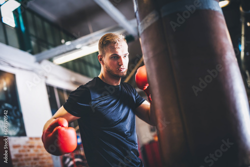 Boxer do boxing training with punchbag on gym photo