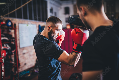 Man on boxing training with instructor on gym photo