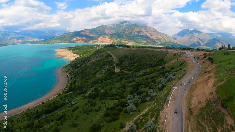 paragliding in Uzbekistan. paraglider flying over the Amirsoy ski slope and Charvak lake along the road with cars. Extreme and active types of recreation. view from gopro. High quality FullHD footage