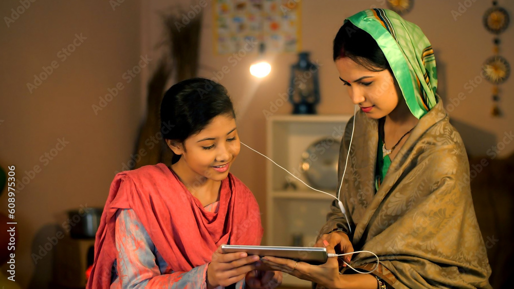 A young girl and her middle-aged mother watching an online video on a tablet - village home  entertainment  digital device. A modern village family using a tablet together - social media  internet ... - obrazy, fototapety, plakaty 