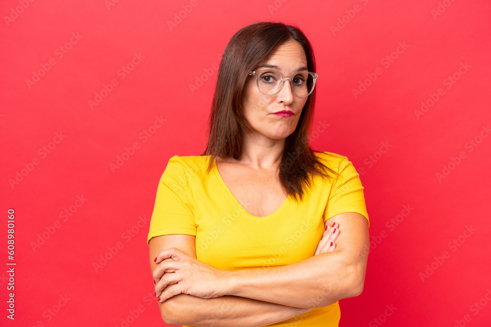 Middle-aged caucasian woman isolated on red background feeling upset Middle-aged caucasian woman isolated on red background feeling upset