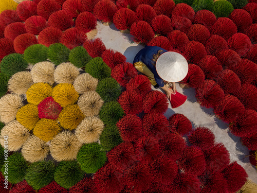 Woman with beautify arrangement of colorful incense sticks photo