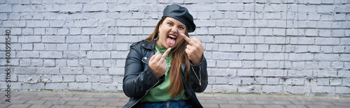 Εκτύπωση καμβά sassy plus size woman sitting in leather jacket and beret while showing middle f