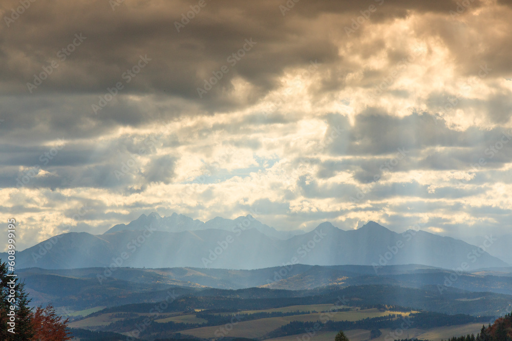 Autumn Tatras seen from the Szopka pass (Chwala Bogu) in Pieniny (Poland) with a cloudy sky with streaks of sun