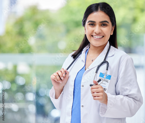 Young woman, doctor and hospital portrait with smile, stethoscope and healthcare career with pride. Female latino medic, happy health and wellness expert with medical job, clinic and help in services