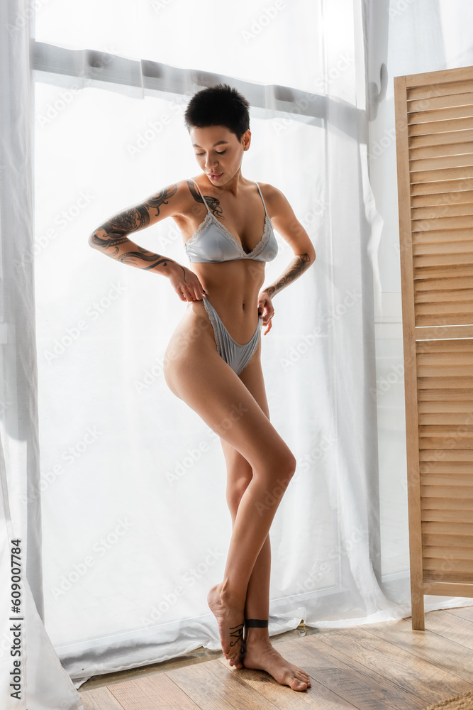 intriguing and seductive tattooed woman with short brunette hair