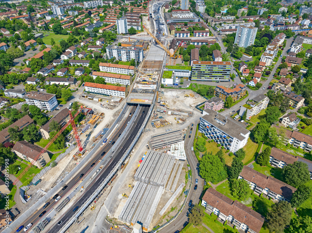 Fototapeta premium Aerial view of City of Zürich North with highway enclosure construction site on a sunny spring day. Photo taken May 27th, 2023, Zurich, Switzerland.