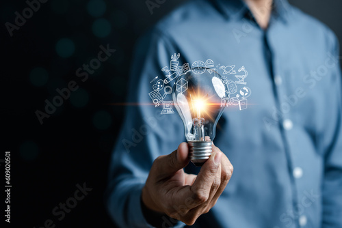 Businessman hand holding light bulb working Creativity, Creative for new idea and innovation with energy and power, growth and success development.
