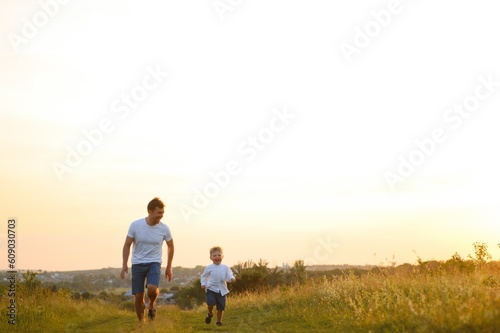 Father's day. Happy family father and toddler son playing and laughing on nature at sunset