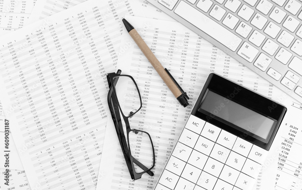 Calculator, keyboard, pen and eye glasses lying on financial statement . Financial concept. Calculator, keyboard, pen and eye glasses lying on financial statement . Financial concept.