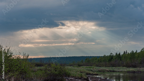 Sunlight pillars shining through clouds in wilderness in Lapland Finland photo