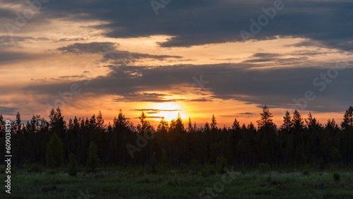 Midnight sun over forests by the Luirojoki river in Finnish Lapland