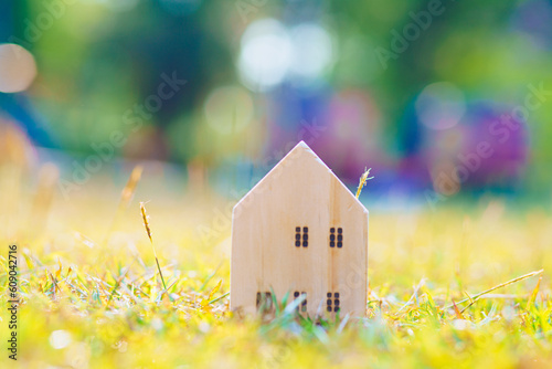 Wooden house model on green grass natire light resident real estate photo