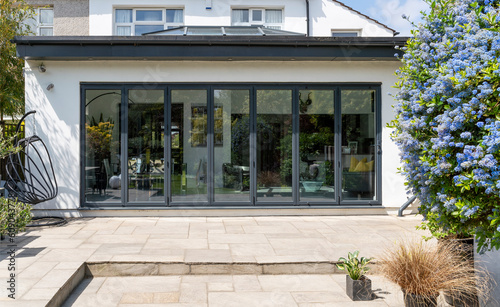 Stylish, closed, bifold doors with plants in spring, summer, revealing interior of a designer, lifestyle, kitchen diner room. photo