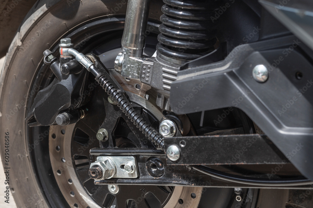 electric motorcycle rear wheel, brake disc and caliper, close up