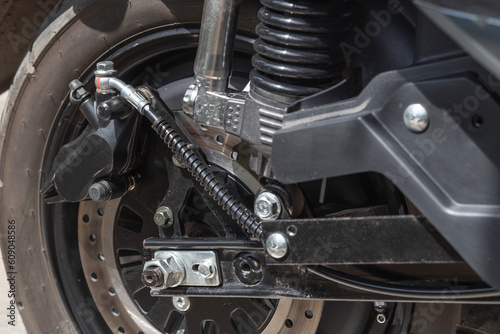 electric motorcycle rear wheel, brake disc and caliper, close up © OLEKSANDR