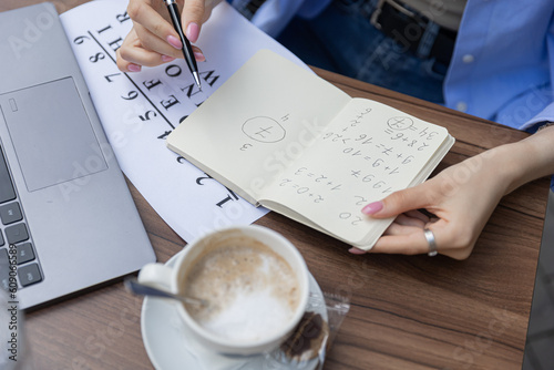 numerologist girl makes a calculation according to numerology, future by date of birth, find out her purpose with the help of numbers top view