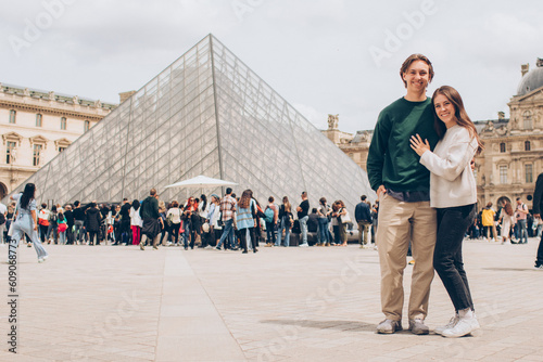 Photo couple standing in front of a crowd at the louvre
