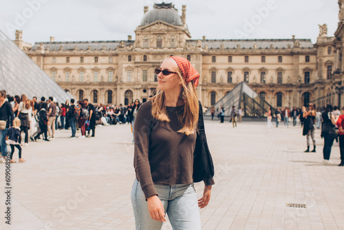 Valokuvatapetti woman tourist wearing a red kerchief and sunglasses at the louvre in paris