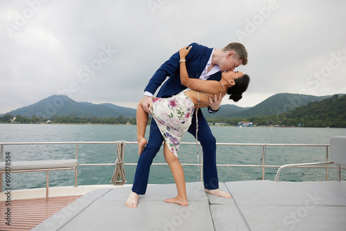 Fototapeta young couple smiling and hugging each other on luxury yacht