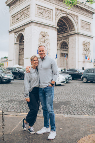 Photography couple standing in front of the arc de triomphe in paris france