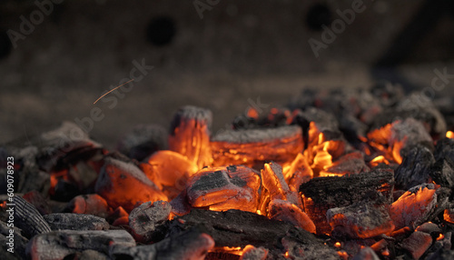 Ember of charcoal on a grill. Close-up of glowing charcoal and hot embers. Heat, temperature, barbecue time.