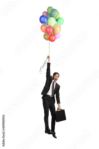Fototapeta Naklejka Na Ścianę i Meble -  Businessman holding balloons and flying up