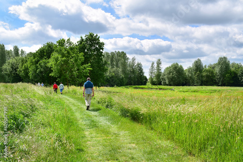 People walking in green countryside landscape in Belgium