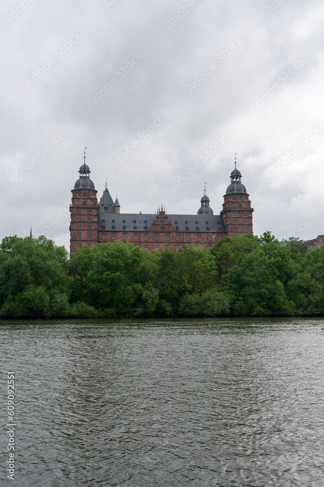 Castle in Aschaffenburg with a river and a cloudy sky