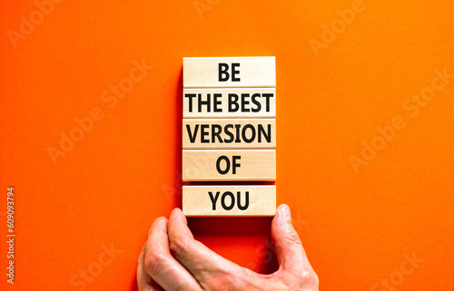 Motivational and inspirational symbol. Concept words Be the best version of you on wooden block. Beautiful orange background Businessman hand. Business motivational inspirational concept. Copy space.