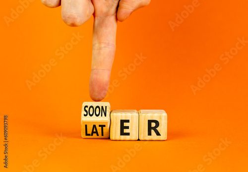 Sooner or later symbol. Businessman turns wooden cubes and changes the word Later to Sooner. Beautiful orange table orange background. Copy space. Business and sooner or later concept.