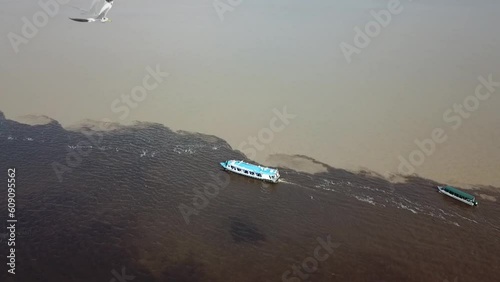 Aérea drone sobre barco navegando no encontro dos Rios Negro e Solimões, Amazonas, Brasil photo