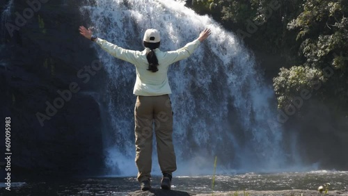 Slow de turista erguendo os braços contemplando cachoeira do Bracuí no Brasil photo