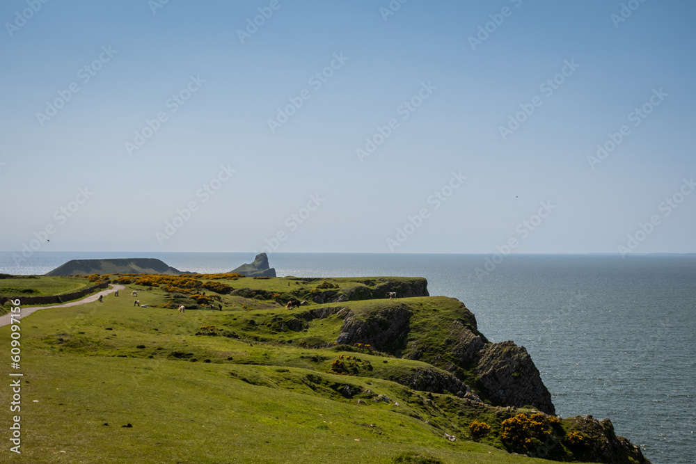 View from the top of worms head looking over the cliff to the sea water on a sunny summer day in South Wales UK on the Gower peninsula. Rugged natural beauty from British outdoor landscape 