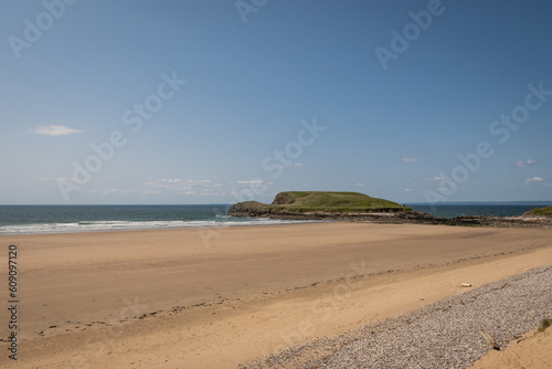Sandy beach on Rhossili Bay, Gower peninsula, South Wales, UK. popular British coastal staycation getaway in area of outstanding natural beauty for outdoor lifestyle and rugged adventure in nature
