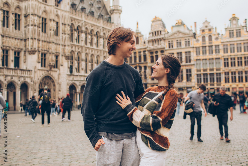 couple standing in front of a crowded city center in europe grand palace