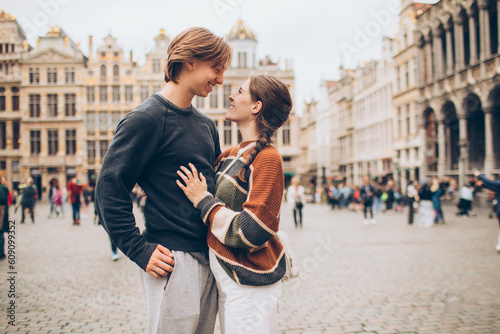 couple standing in front of a crowded city center in europe grand palace