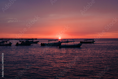 Atardecer en el mar con botes