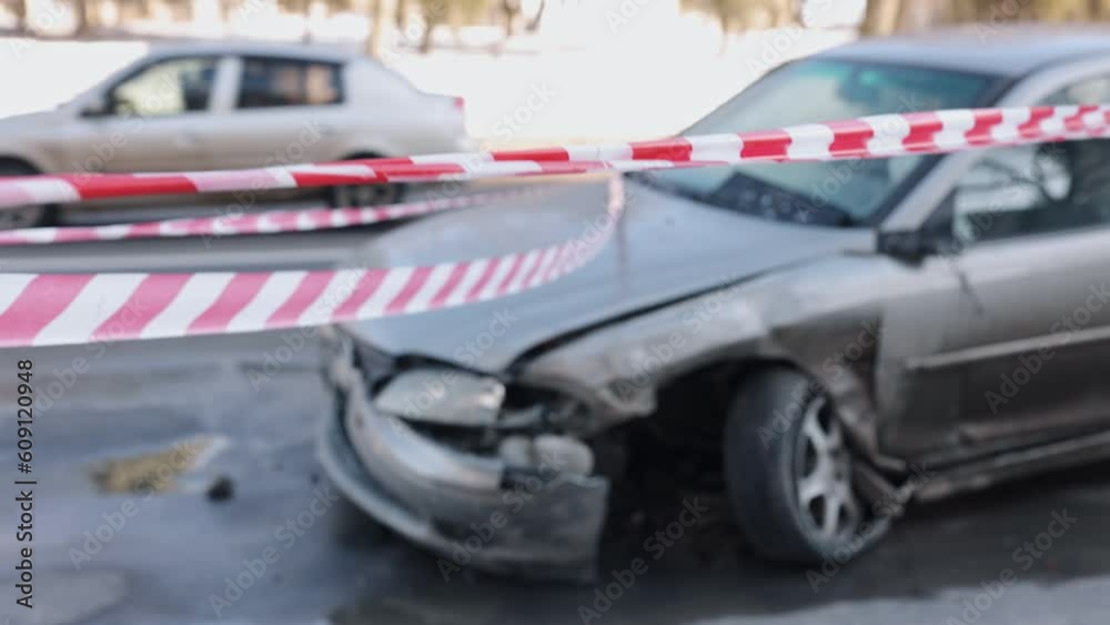 Crash accident, smashed automobile, vehicle crash. Encircled by hazard tape, car sustained significant damage to front section after accident.