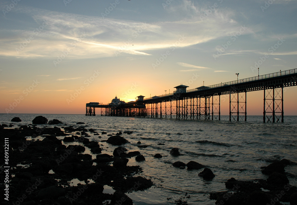 Obraz premium The sun rising over Llandudno pier.